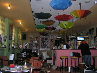 Ombonat kafé i Poprad. I ett hörn finns en stor hylla välförsedd med böcker.